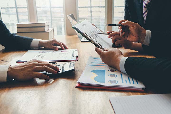 Unlock Capital: The Basics of Stock Loans & Credits; Group of business people meeting together to assess business profits.